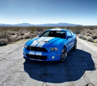 Impresionante Ford Mustang GT azul en una carretera desértica