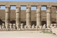 Ruinas de un templo mortuorio egipcio antiguo con columnas icónicas y estatuas de esfinge