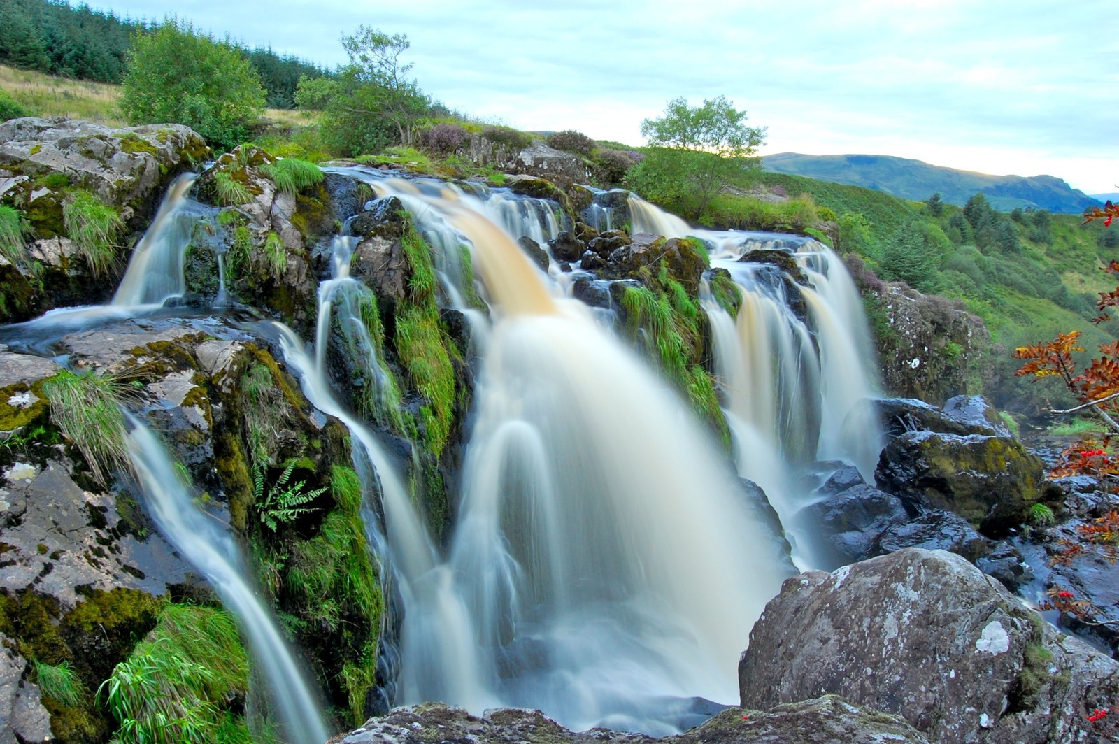 Waterfall with a lot of water flowing over it in a valley (waterfall, watercourse, nature reserve, water resources, body of water)