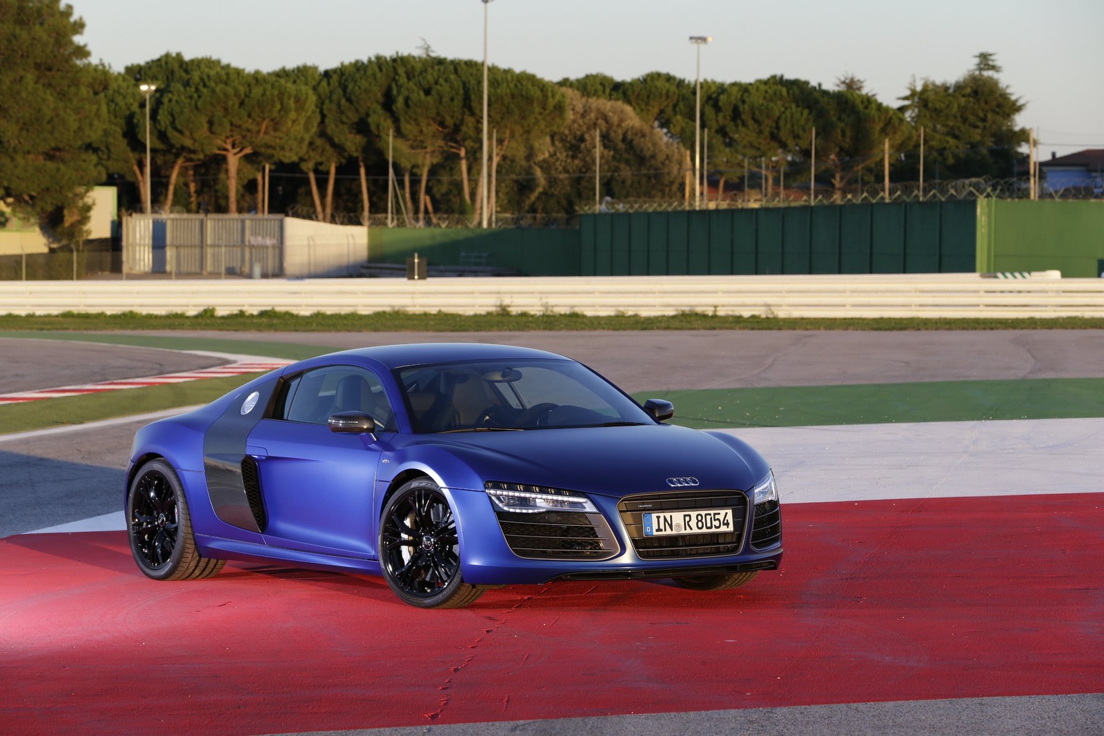 A blue audi sports car driving on a track with trees in the background (audi r8, car, audi, v10 engine, supercar)