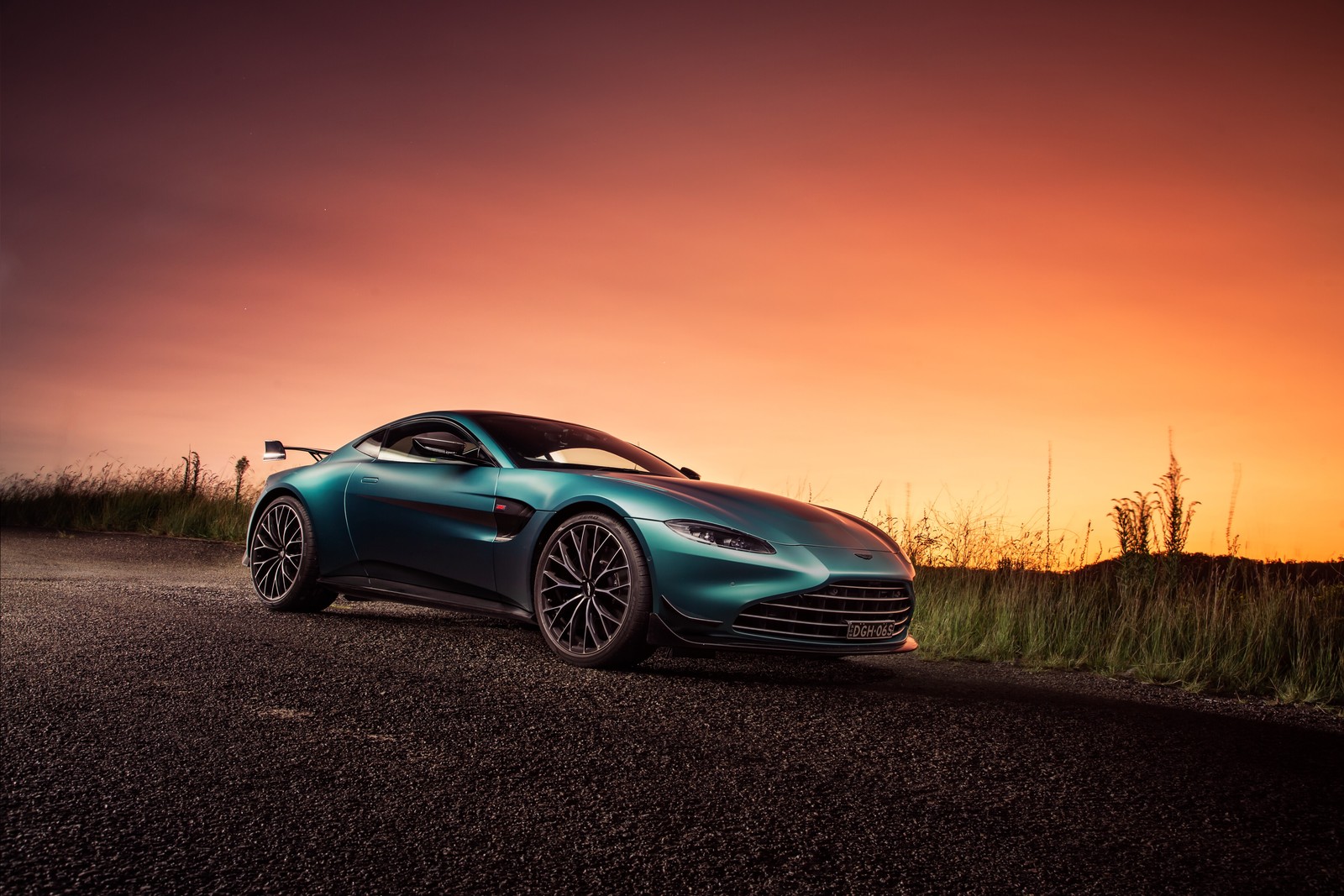 Une voiture de sport bleue garée sur une route au coucher du soleil (aston martin vantage, édition f1, voitures, fond décran 4k)