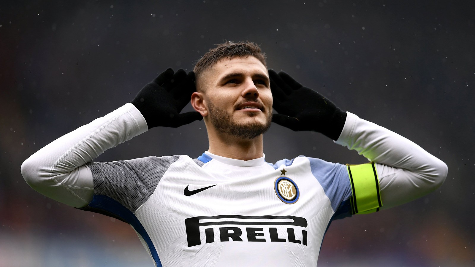 Un hombre con una camisa blanca y guantes negros sosteniendo sus manos en la cabeza (mauro icardi, jugador de fútbol, inter de milán, inter milan, deportes)