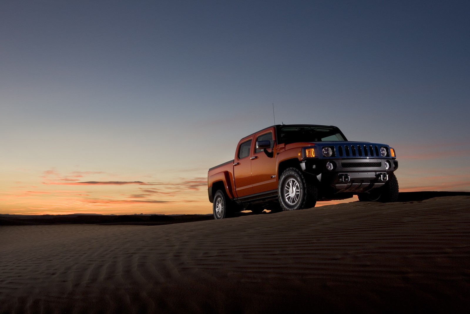 Veículo árabe dirigindo em uma estrada desértica ao pôr do sol (hummer, caminhonete, carro, ambiente natural, areia)