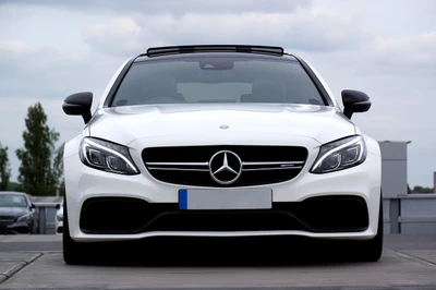 Sleek white Mercedes-Benz C-Class front view, showcasing its sporty grille and luxurious design.