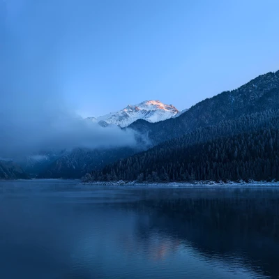 Serene Winter Reflektionen: Schneebedeckte Berge und ruhige Gewässer