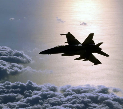 Silhouette du jet F/A-18 Hornet au-dessus des nuages au coucher du soleil