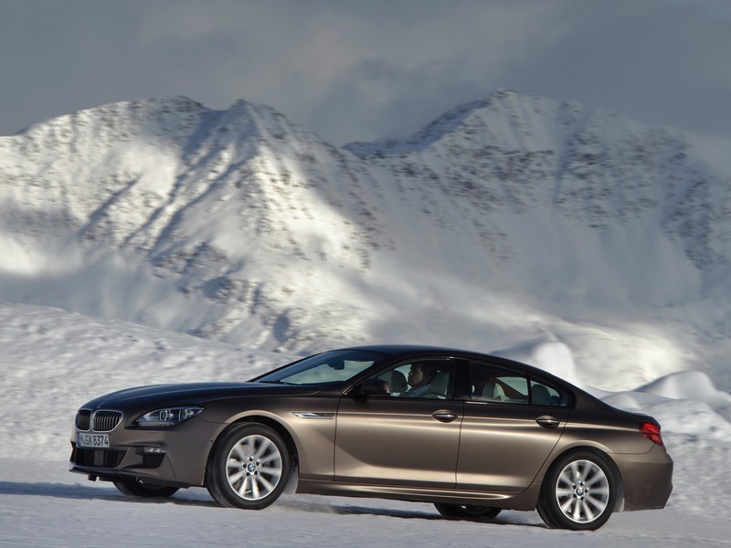 Седан bmw 6 серии едет по заснеженной дороге перед горой (представительский автомобиль, бмв 6 серии, bmw 6 series, bmw m6, bmw 3 серии гран туризмо)