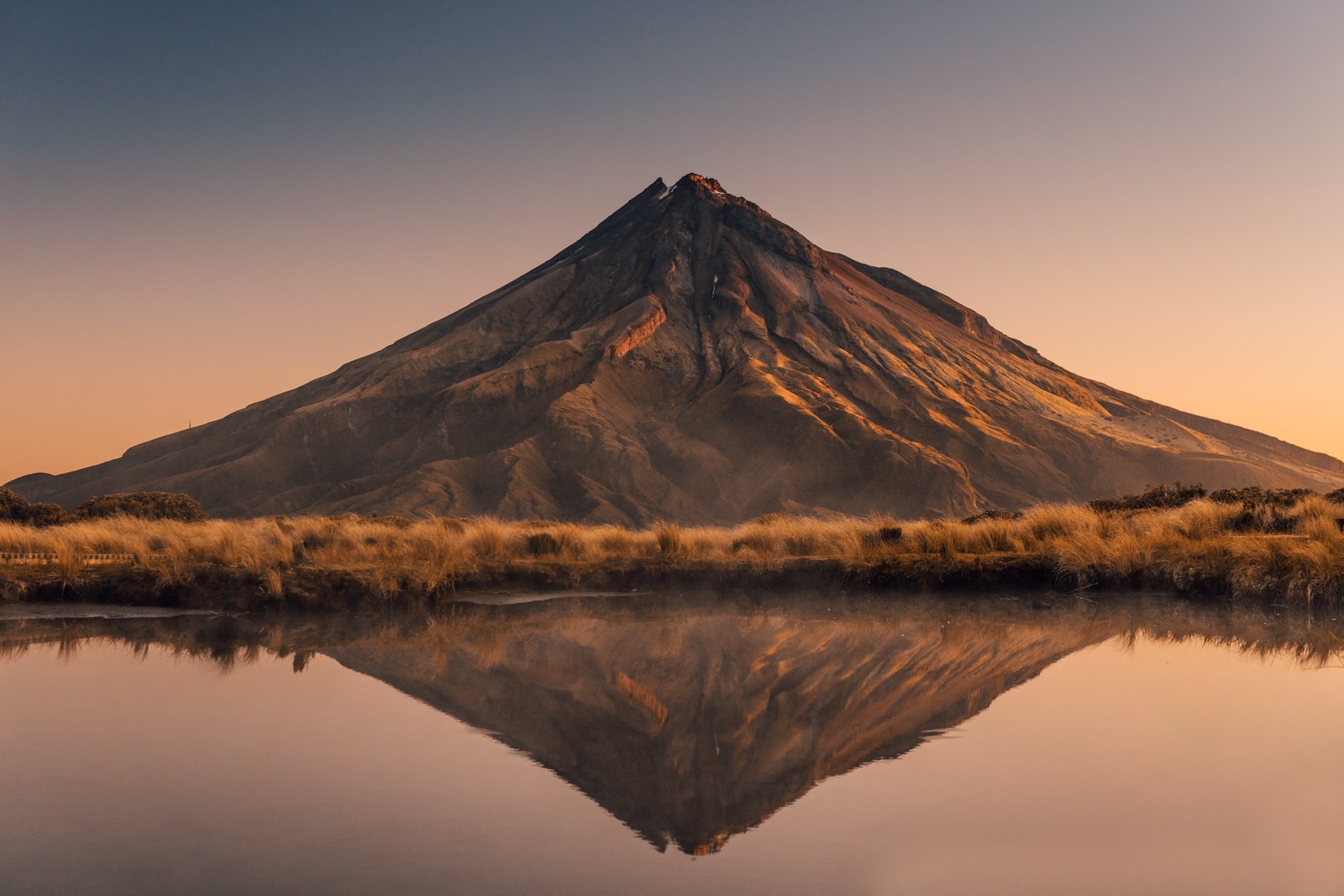 Araffe mountain reflected in a lake at sunset with a clear sky (mountain, travel, hiking, park, national park)