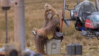 Kelnacca, o acólito Wookiee em Star Wars, senta-se contemplativamente em meio a uma paisagem rugged.