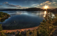 Sereno amanecer de las tierras altas sobre un lago reflectante