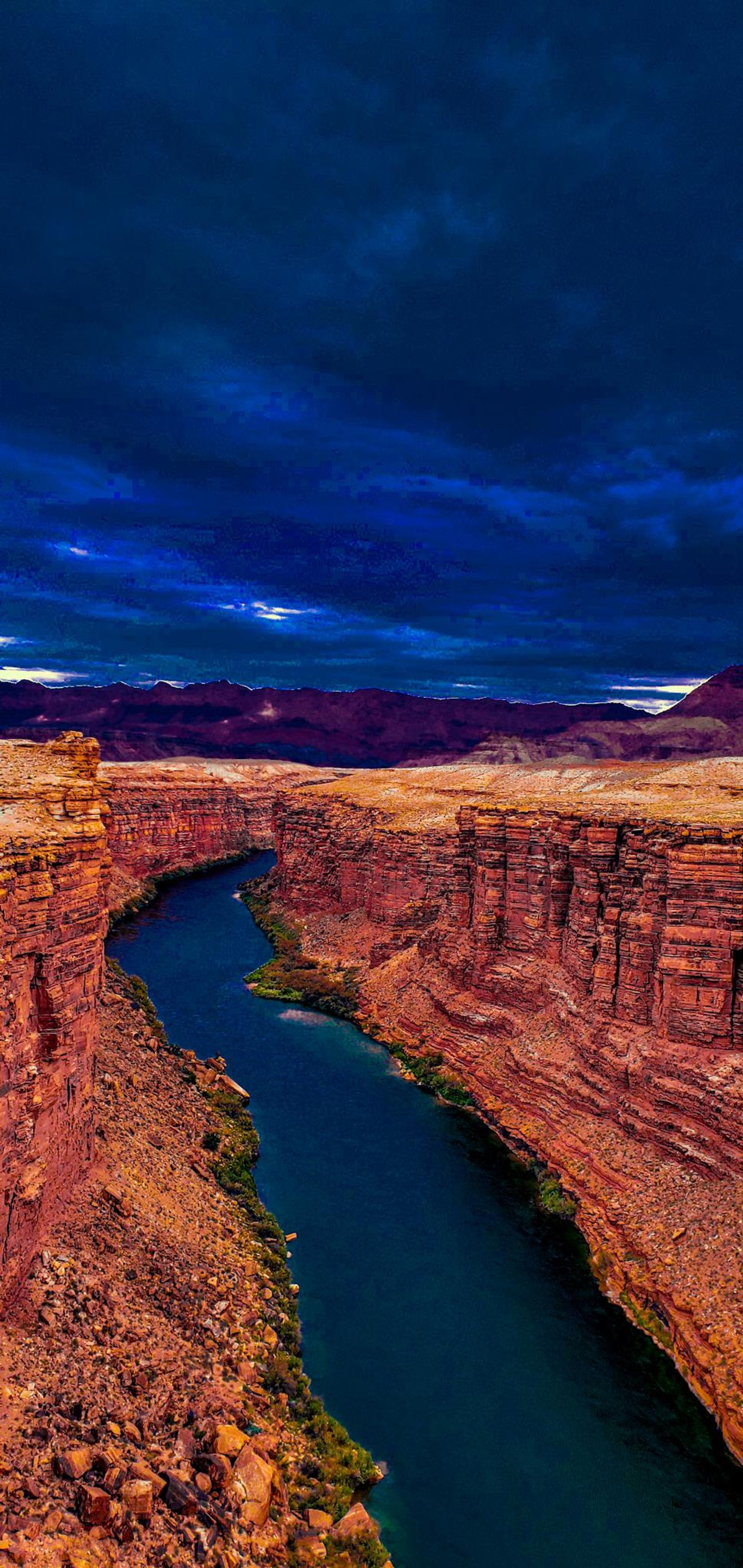 Una vista aérea de un río que corre a través de un cañón bajo un cielo nublado (río colorado, agua, recursos hídricos, nube, mundo)