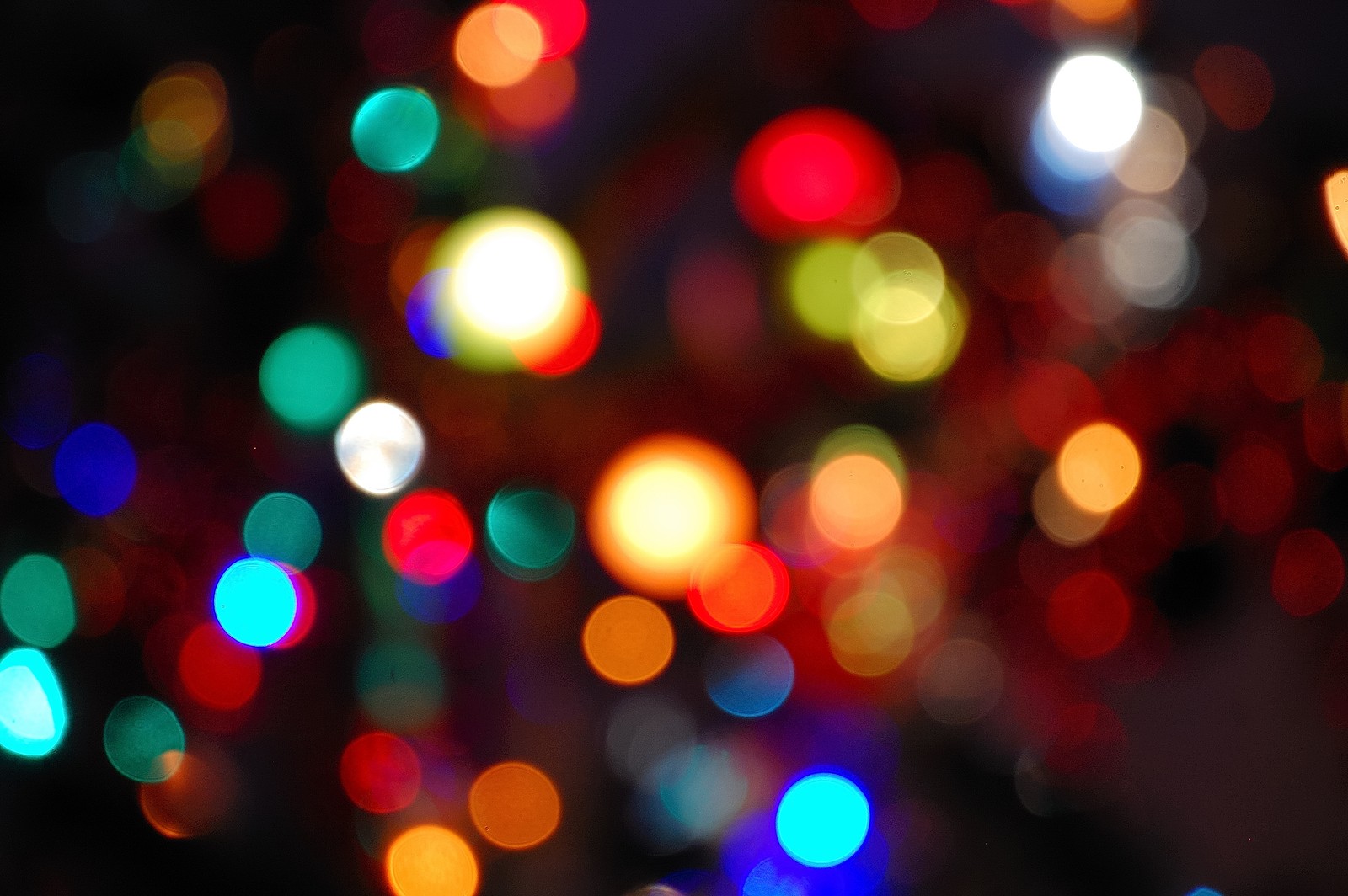 Luzes coloridas brilhando intensamente em um fundo escuro (luz, luzes de natal, cor, iluminação, noite)