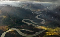 Wickelnder Fluss durch raues Hochlandlandschaft mit Berggipfeln und Tundra