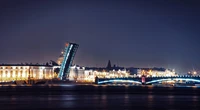 Paisagem urbana noturna iluminada com uma ponte levadiça e reflexos