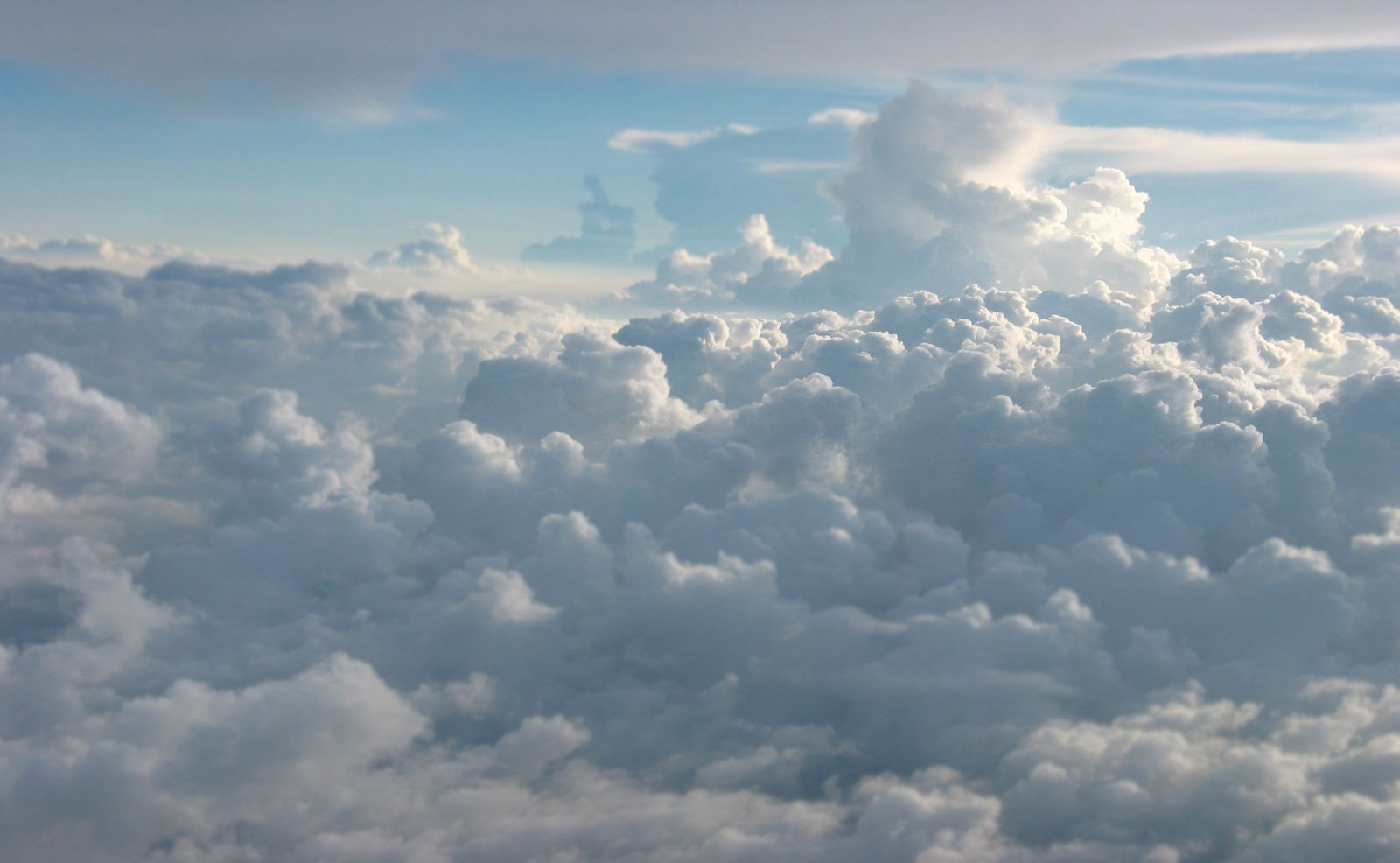 Il y a une vue d'un ciel nuageux depuis un avion. (cumulus, nuage, journée, atmosphère, matin)