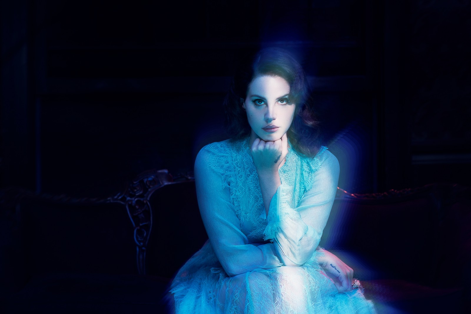 Femme arabe en robe bleue assise sur un canapé (lana del rey, bleu, lumière, beauté, mode)