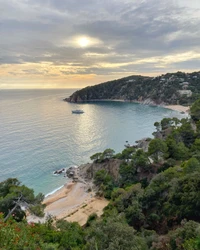 Baía costeira serena ao pôr do sol com arredores exuberantes