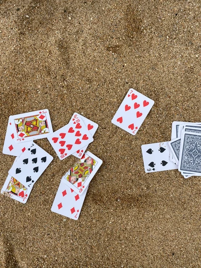 Cartes à jouer éparpillées sur le sable : Un jeu de poker