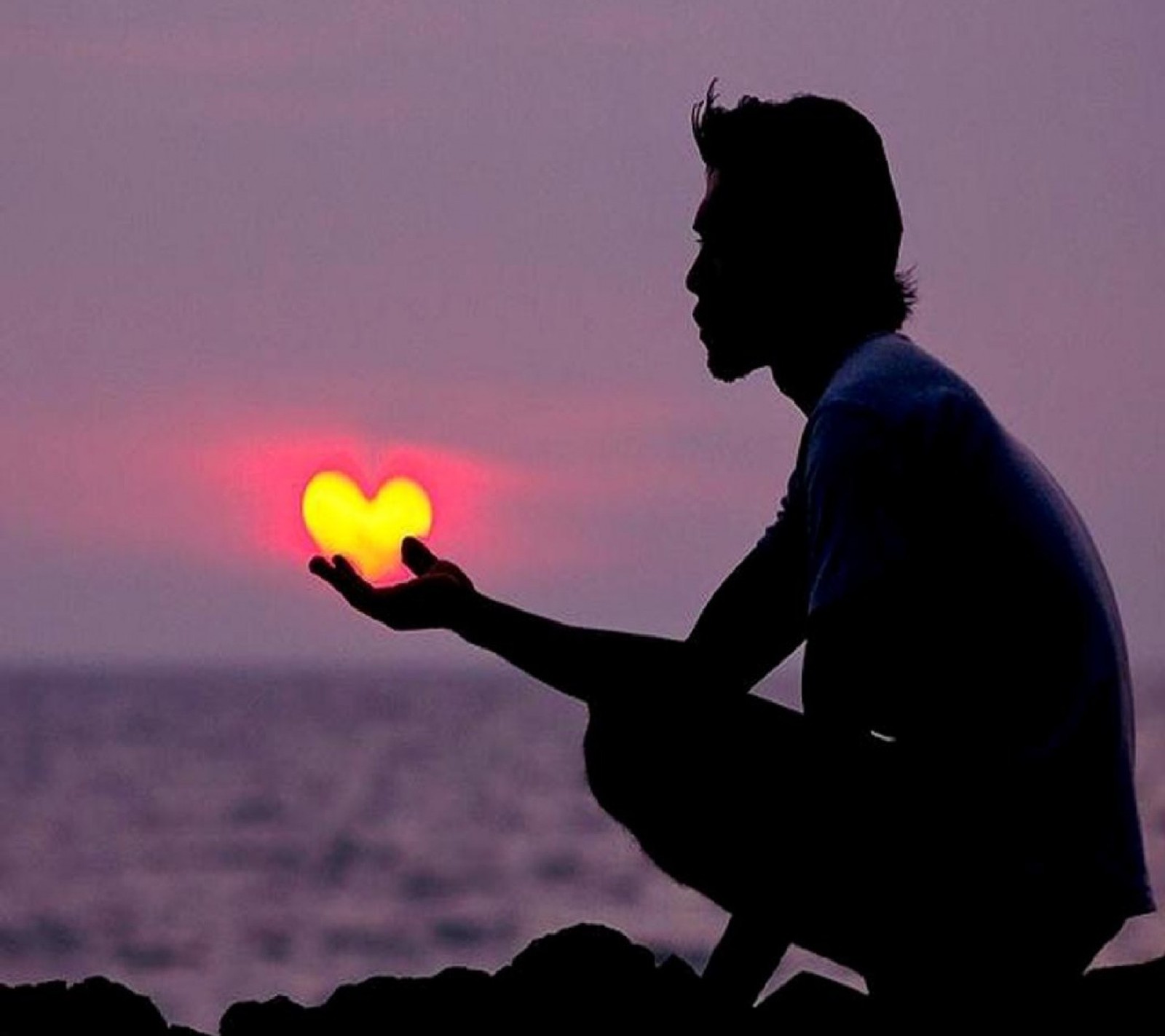 Un hombre árabe sentado en una roca sosteniendo un objeto en forma de corazón (heart on the palm)