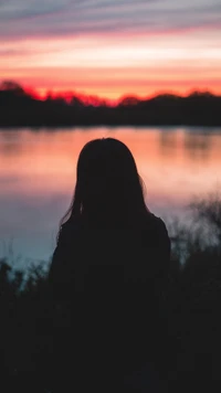 Solitude au coucher du soleil : Une silhouette au bord du lac tranquille