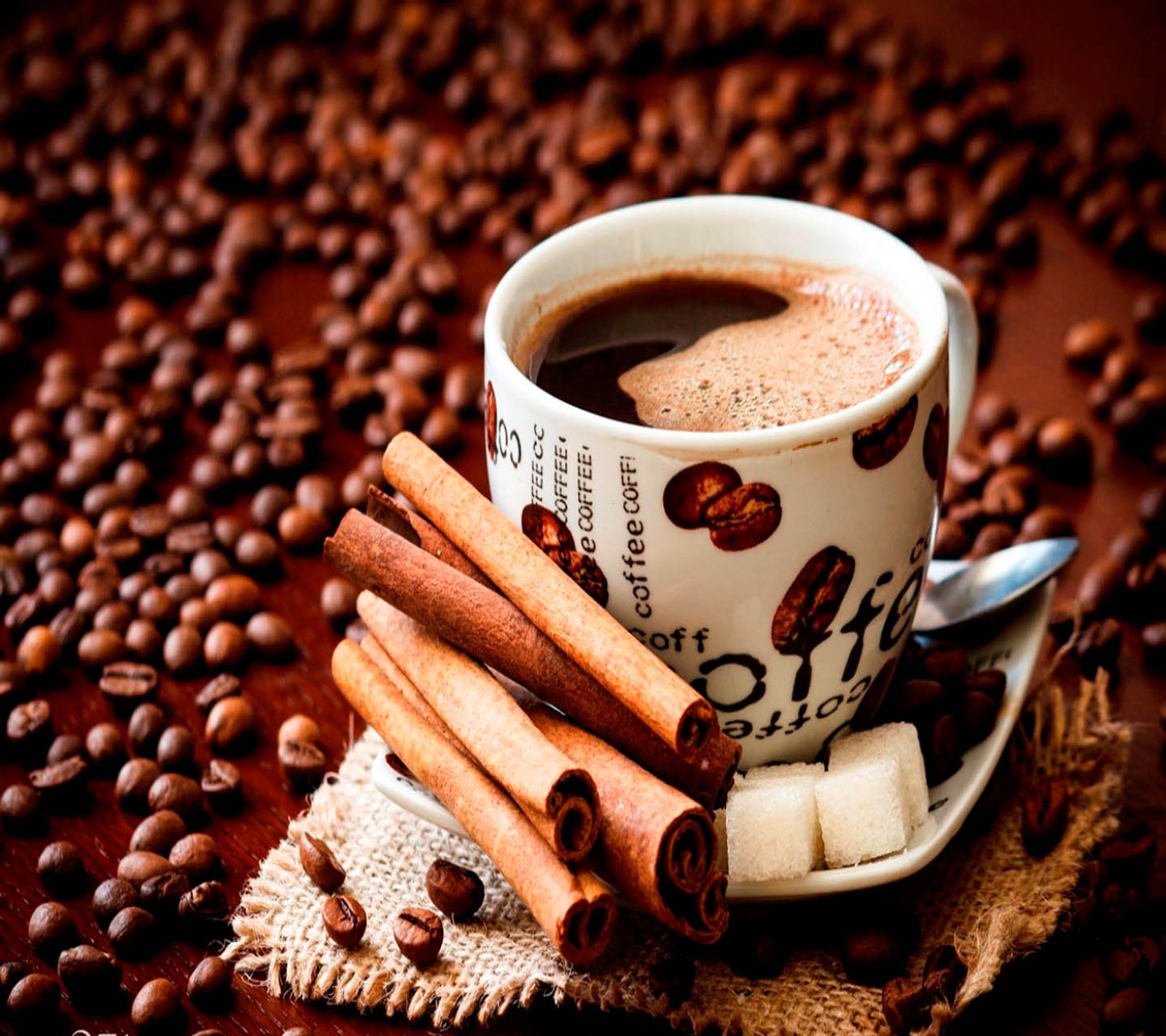 There is a cup of coffee and cinnamon sticks on a table (coffee, time)