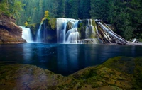 Chute d'eau majestueuse se déversant dans une piscine sereine entourée d'une forêt luxuriante.