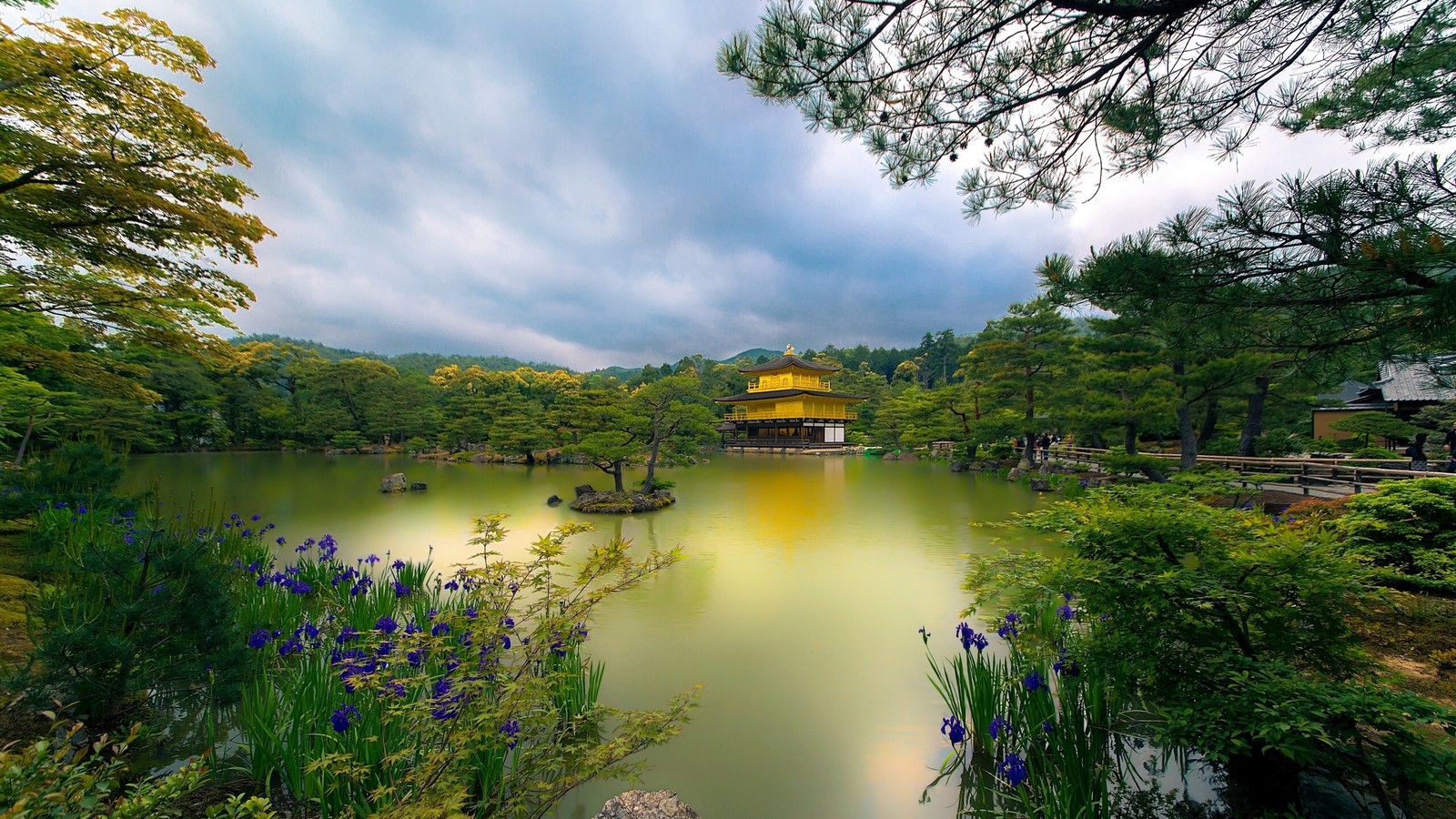 A view of a pond with a yellow pavilion in the middle (temple, nature, body of water, reflection, water)