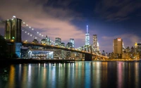 Horizonte da cidade de Nova Iorque à noite com reflexo da Ponte do Brooklyn