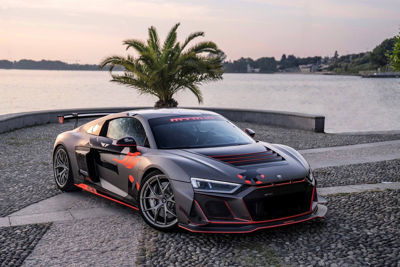 Um close em um carro esportivo estacionado perto de um corpo de água (mtm audi r8 gt4 street, carros esportivos, kit de desempenho, ajuste personalizado, 2021)