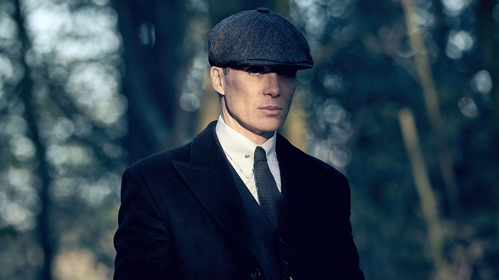 Hay un hombre en traje y sombrero parado en el bosque (cillian murphy tommy shelby, genial, peaky blinders, 5k, películas)