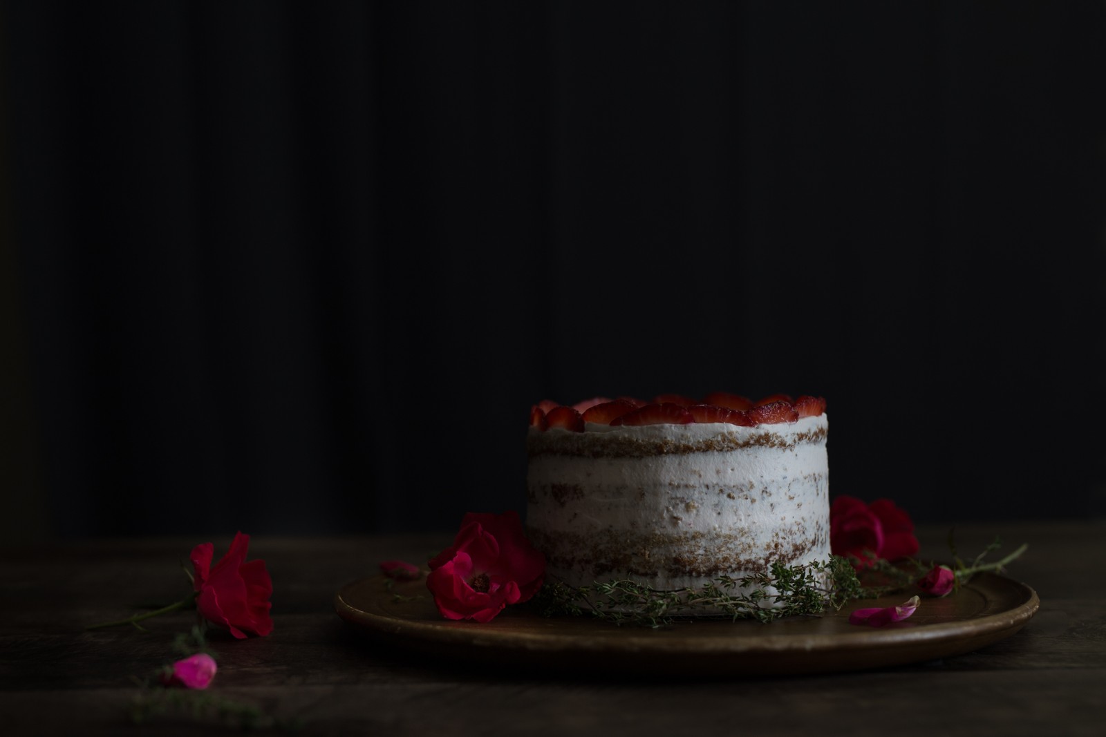 Hay un pastel con fresas en un plato con flores (pastelito, pastel, postre, glaseado, horneado)