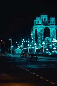 Estrada urbana iluminada à noite com marco arquitetônico