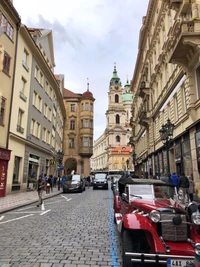 Charming Street Scene in Prague with Historic Architecture and Classic Car