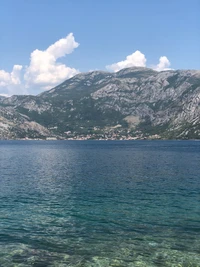 Reflexão serena do lago em meio a paisagens montanhosas e céus azuis