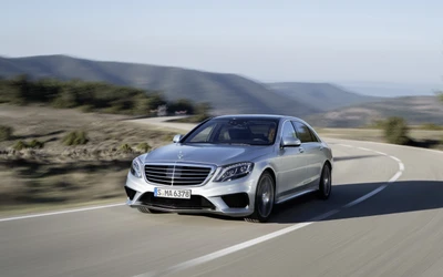 Mercedes-Benz S-Klasse AMG in Bewegung auf einer malerischen kurvenreichen Straße.