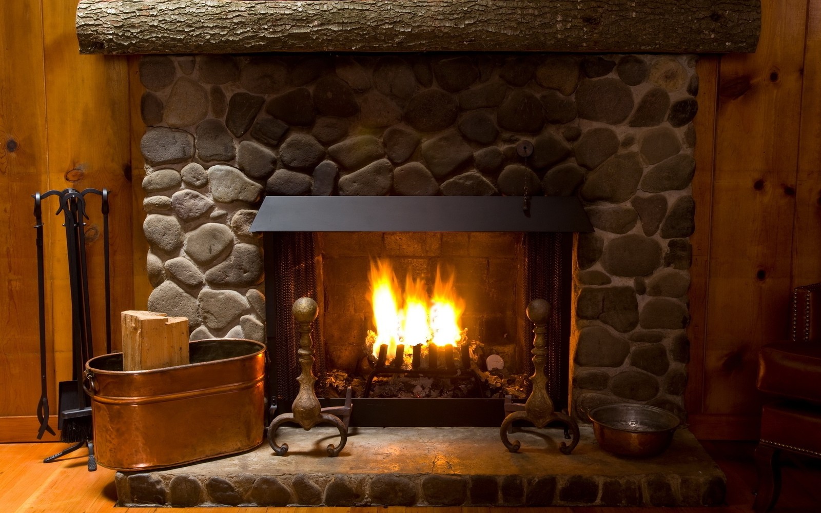 Une cheminée avec des bûches dans un chalet rustique (cheminée, foyer, chaleur, poêle à bois, mantel de cheminée)