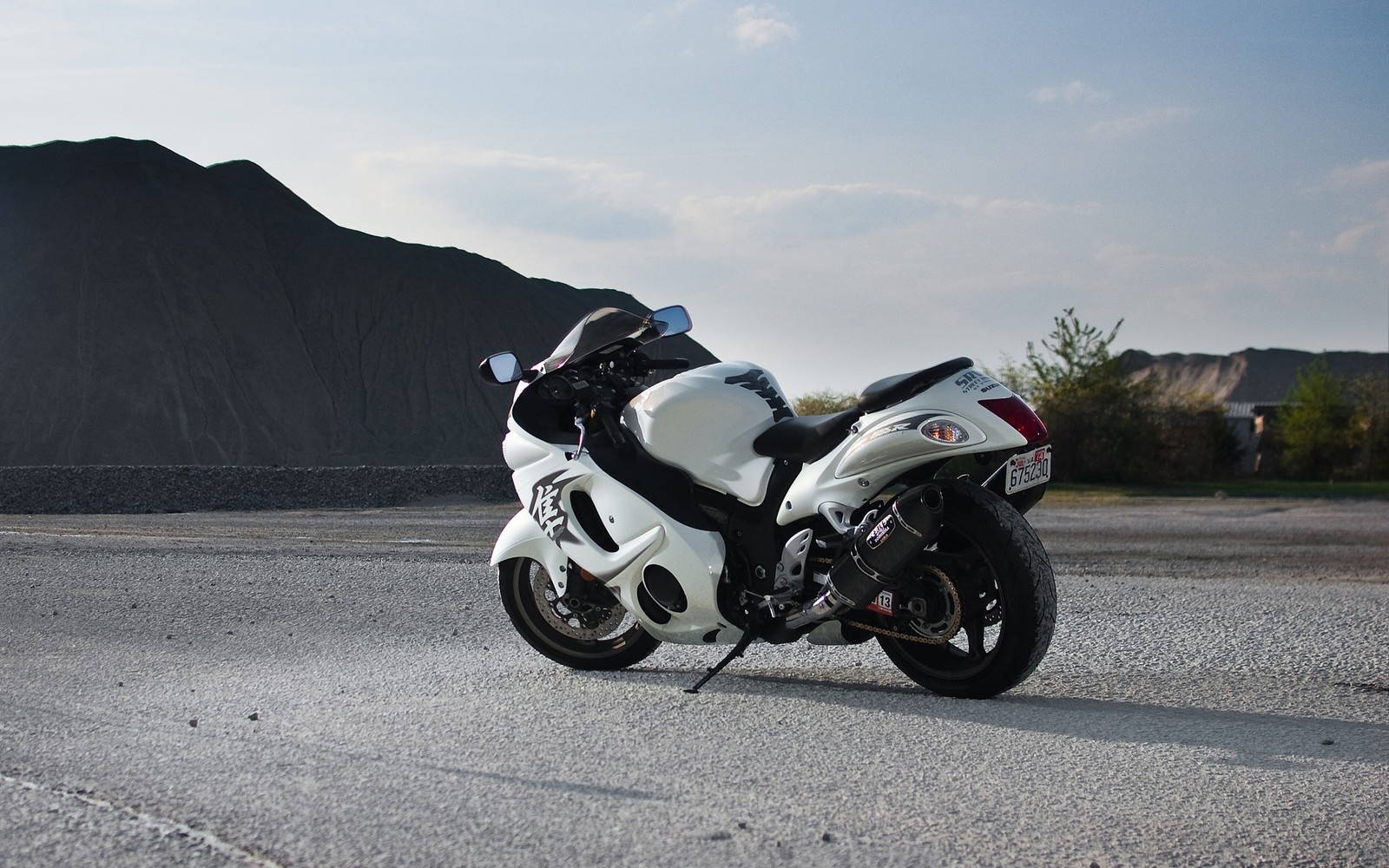 Une moto est garée sur le bord de la route (suzuki, suzuki hayabusa, moto, moto de sport, voiture)