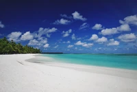 Unberührte weiße Sandstrände treffen auf türkisfarbenes Wasser unter einem lebhaften blauen Himmel und schaffen ein ruhiges tropisches Strandparadies.