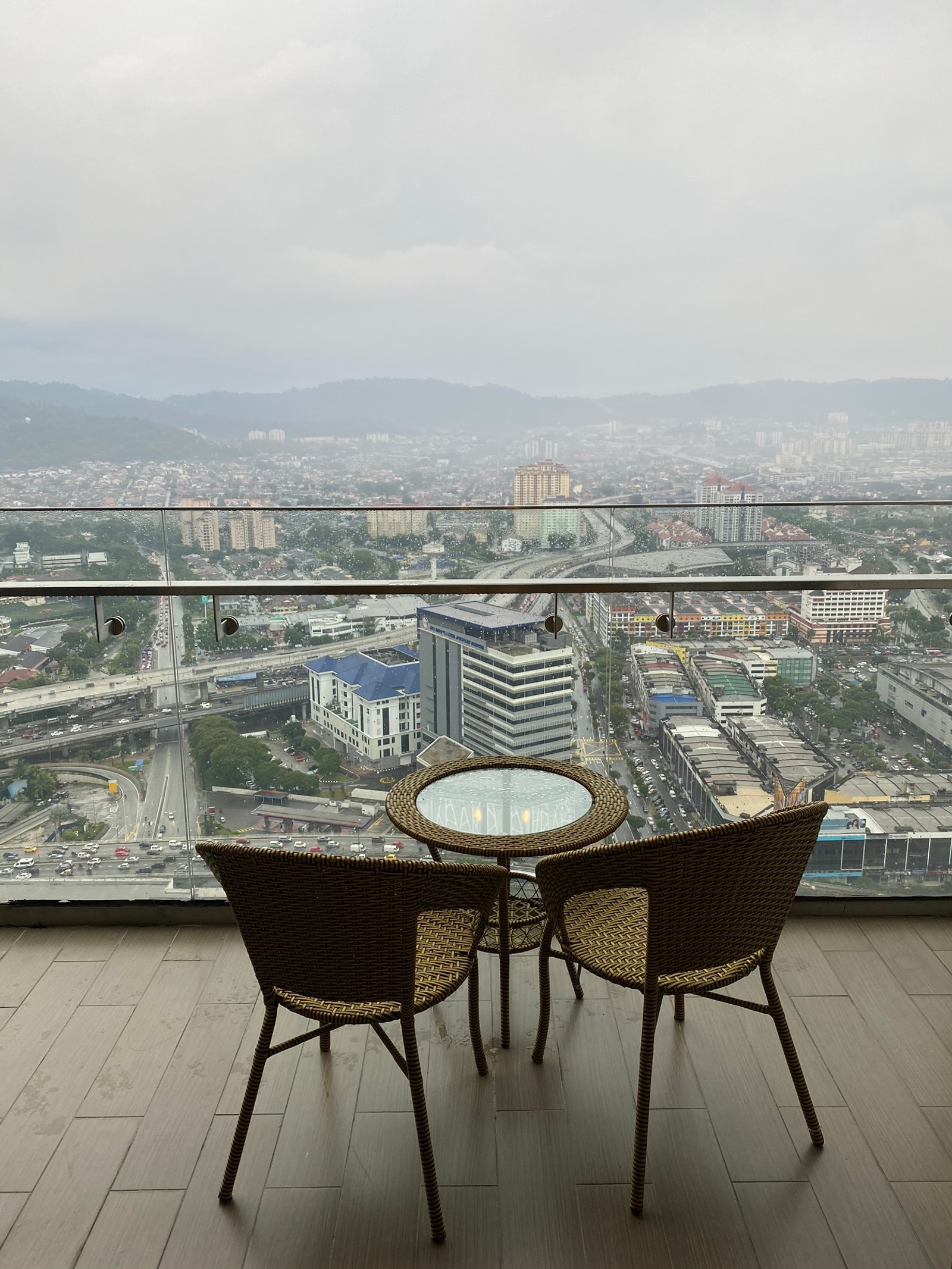 Há duas cadeiras e uma mesa na varanda de um prédio (arquitetura, apartamento penthouse, imóveis, lar, mesa)