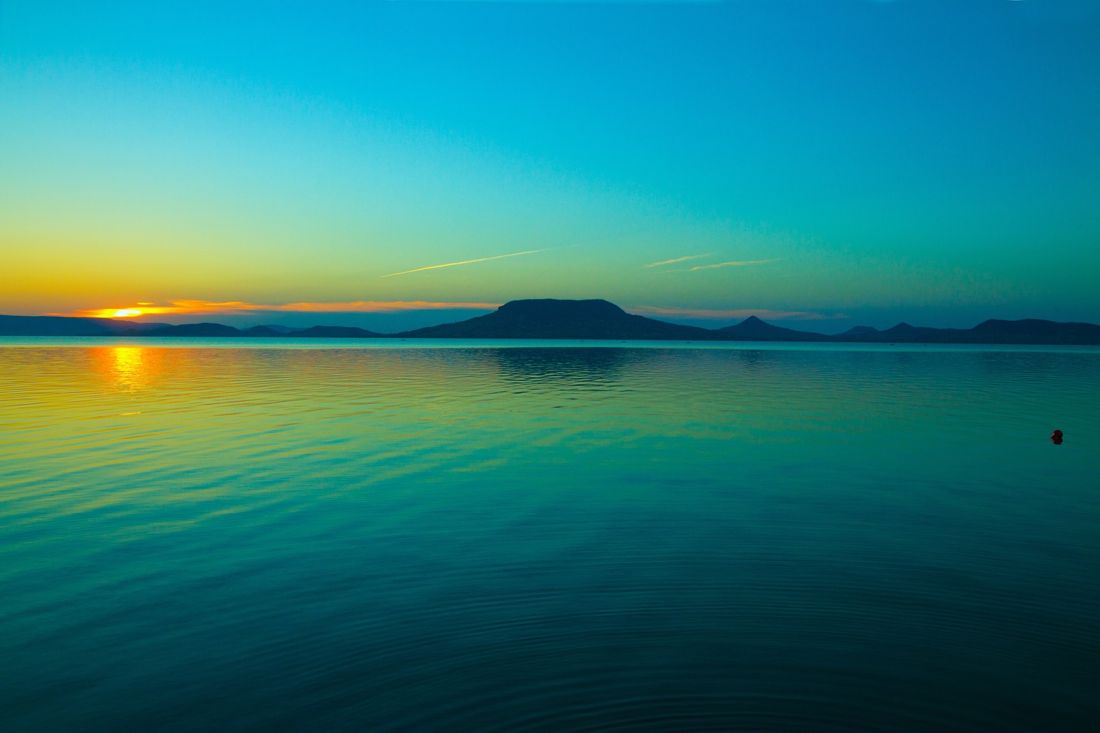 A view of a body of water with a boat in the distance (morning, night, sea, summer, sun)