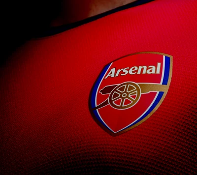 Emblema del club Arsenal en camiseta roja