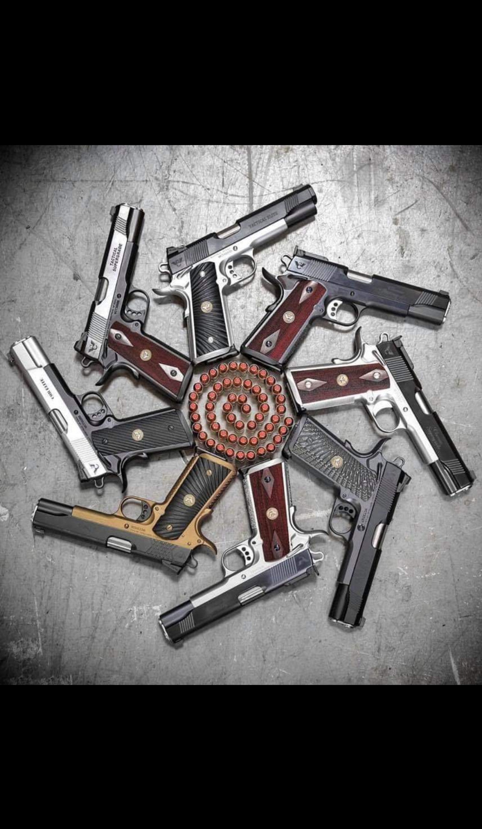 Several different types of guns arranged in a circle on a table (bullet, colt, glock, kill, pistol)