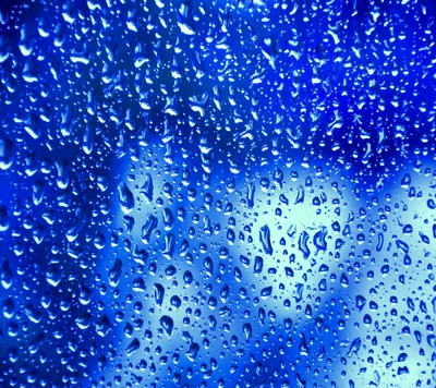 Abstrakte blaue Regentropfen auf dem Fenster