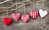 Adornos de corazón hechos a mano colgando de ramas en madera rústica, perfectos para el Día de San Valentín y decoraciones festivas.