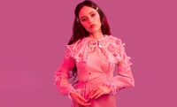 Jenna Ortega em um vestido rosa contra um fundo rosa vibrante.