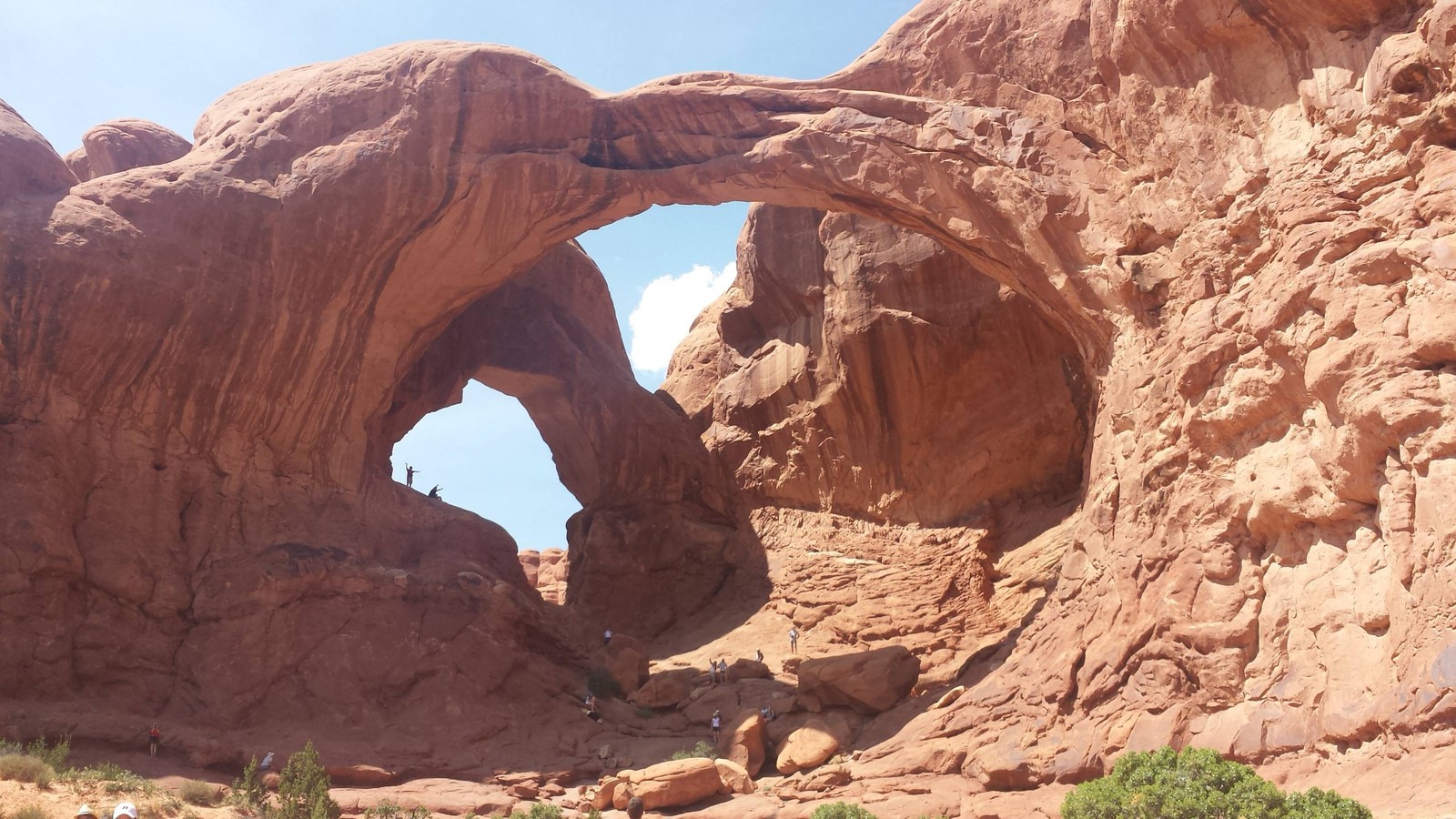 Il y a une grande formation rocheuse avec un grand arc (arc naturel, delicate arch, parc national, parc national des glaciers, parc national de zion)