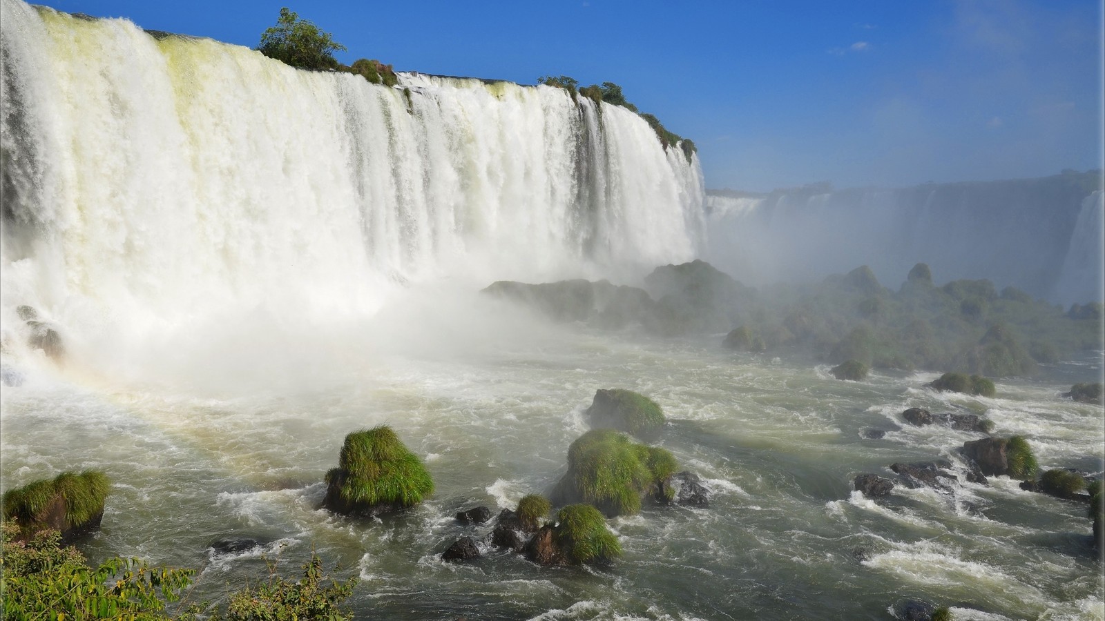 Un gros plan d'une cascade avec un arc-en-ciel dans le ciel (la cascade, plan deau, ressources en eau, eau, cours deau)