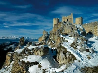 Schneebedeckte Burgruinen zwischen majestätischen Alpenbergen