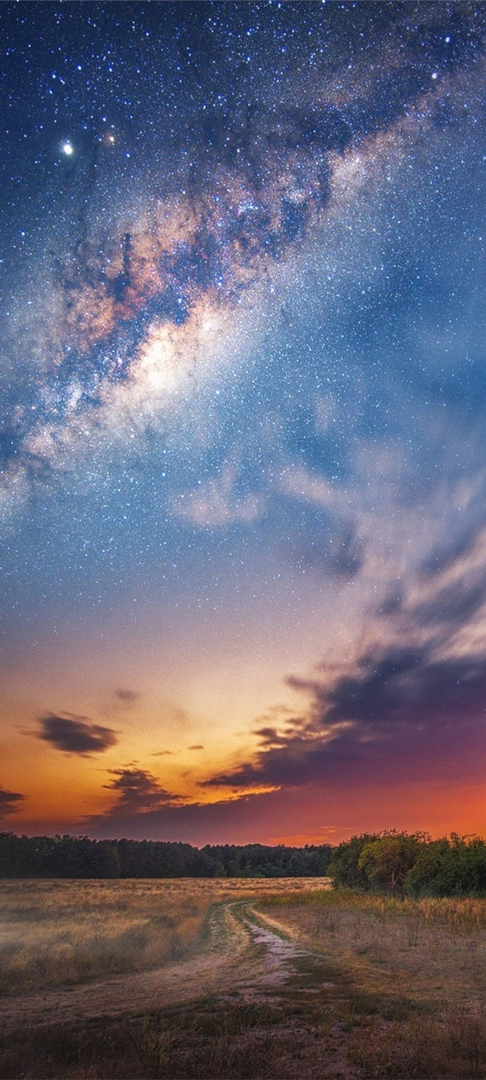 Vista aérea de um campo com uma estrada de terra e um céu cheio de estrelas (via láctea, galáxia, estrela, astronomia, objeto astronômico)