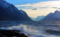 Majestic Fjord at Sunset with Waves Crashing Against Rocky Shoreline